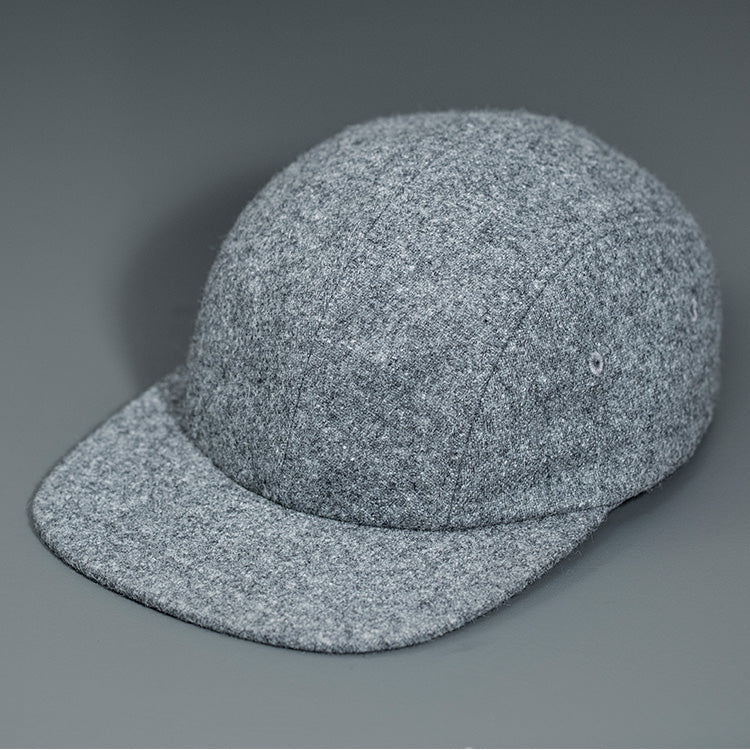 A Heather Grey, Melton Wool, Blank 4 Panel Hat with a Flat Bill, & Vegan Leather Strapback.  Designed by Blvnk Headwear.