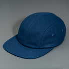 A Navy, Melton Wool, Blank 4 Panel Hat with a Flat Bill, & Vegan Leather Strapback.  Designed by Blvnk Headwear.