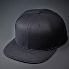 A Black Blank Flex Fit flat bill hat available in S/M & L/XL.  Designed by Blvnk Headwear.