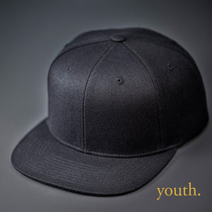 A Youth Sized, Black, Wool, 6 Panel, Flat Bill, Blank Snapback.  Designed by Blvnk Headwear.