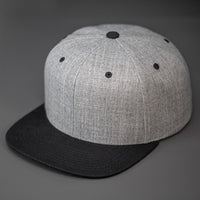 A Heather Grey & Black, Wool, 6 Panel, Flat Bill, Blank Snapback.  Designed by Blvnk Headwear.