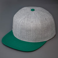 A Heather Grey & Green, Wool, 6 Panel, Flat Bill, Blank Snapback.  Designed by Blvnk Headwear.