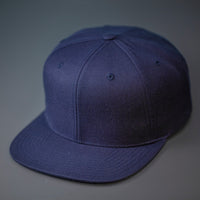 A Navy, Wool, 6 Panel, Flat Bill, Blank Snapback.  Designed by Blvnk Headwear.