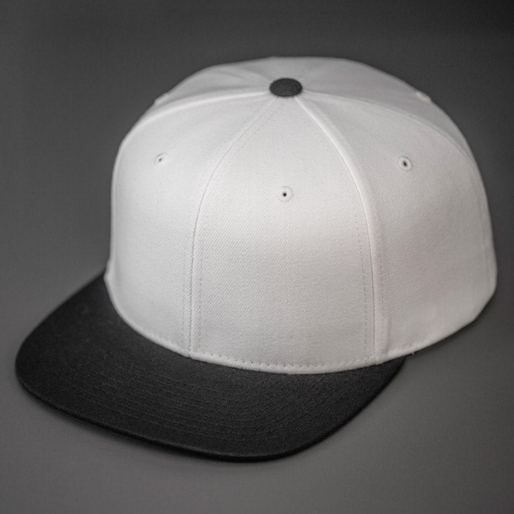 A White & Black, Wool, 6 Panel, Flat Bill, Blank Snapback.  Designed by Blvnk Headwear.