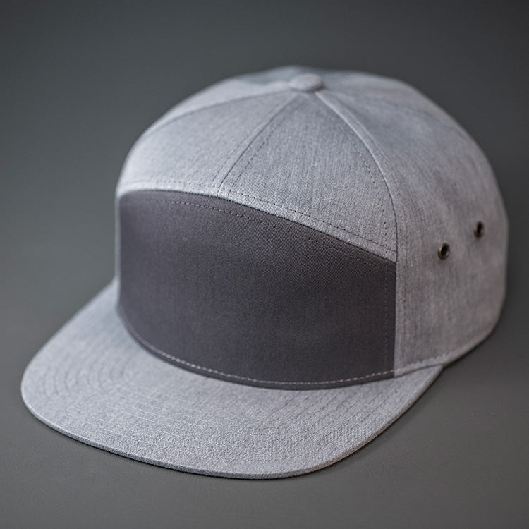 A Charcoal & Heather Grey, Cotton Twill, Blank 7 Panel Hat with a Flat Bill, Brass Details, & Vegan Leather Strapback.  Designed by Blvnk Headwear