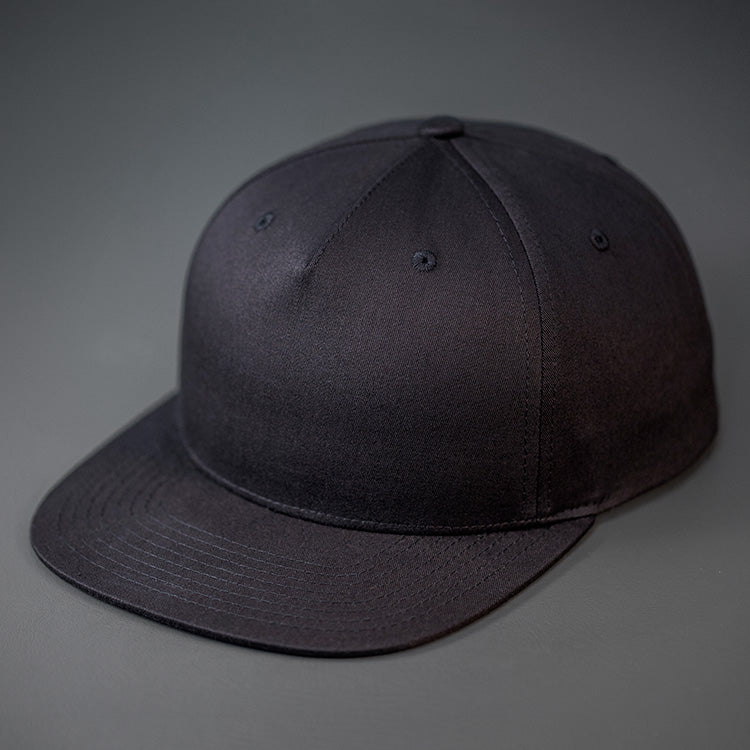 A Black, Cotton Twill, Pinch Front, Blank Snapback Hat.  Designed & Manufactured by Blvnk Headwear.