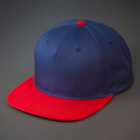 A Navy & Red Colored, Cotton Twill, Pinch Front, Blank Snapback Hat.  Designed & Manufactured by Blvnk Headwear.