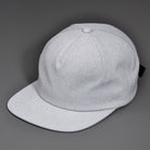A Heather Grey Chambray, Blank 1 Panel Hat, W/ a Flat Bill & Woven Nylon Strapback.  Designed by Blvnk Headwear.