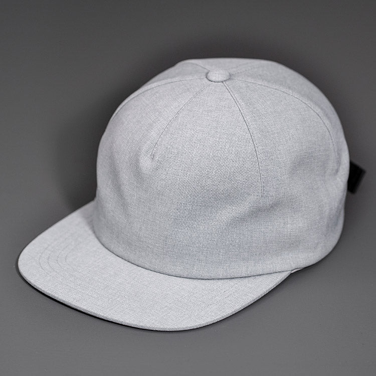A Heather Grey Chambray, Blank 1 Panel Hat, W/ a Flat Bill & Woven Nylon Strapback.  Designed by Blvnk Headwear.