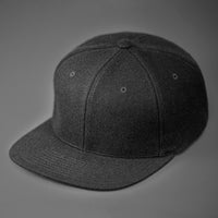 A Black, Melton Wool, Blank 6 Panel Hat With a Flat Bill.  Designed by Blvnk Headwear.