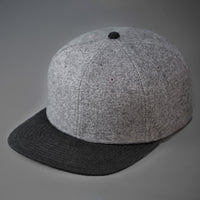 A Heather Grey & Black, Melton Wool, Blank 6 Panel Hat With a Flat Bill.  Designed by Blvnk Headwear.