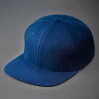 A Navy Blue, Melton Wool, Blank 6 Panel Hat With a Flat Bill.  Designed by Blvnk Headwear.