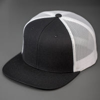 A Black Wool Crown, Blank Trucker Hat, With White Mesh Back Panels, Flat Bill & Classic Snapback.  Designed by Blvnk Headwear.