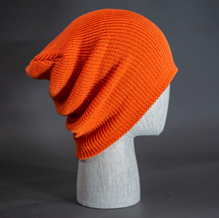 A Blaze Orange colored, super slouch knit blank beanie. Designed by Blvnk Headwear.