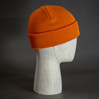 The Longshore Beanie, an burnt orange colored, tight knit, short length blank beanie. Designed by Blvnk Headwear.