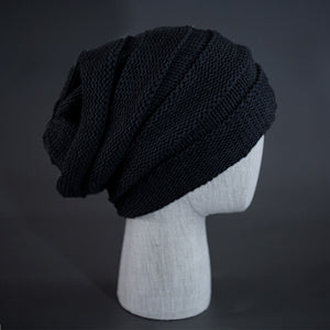 A black colored, alternating rib knit blank beanie with a pre scrunched back.  Designed by Blvnk Headwear.