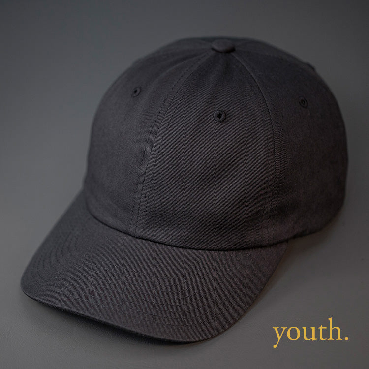 A Youth Sized, Black, Premium Cotton, 6 Panel Crown, Blank Dad Hat.  Designed by Blvnk Headwear.